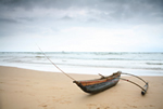 A fisherman's outrigger under a stormy sky on Bentota Beach
